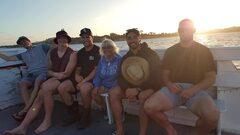 Youth group relaxing on deck at sunset